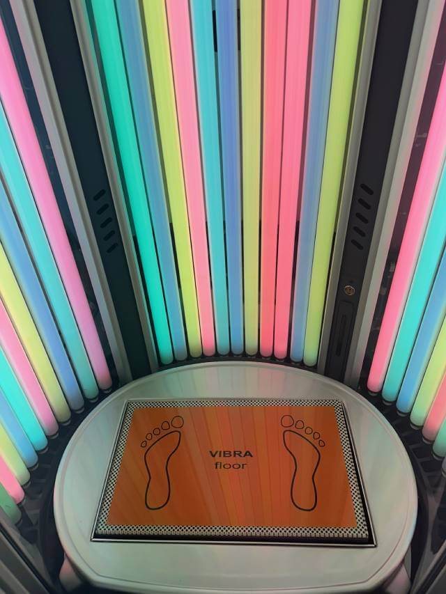 Insidan av ett ståsolarium med Rainbow Tan-rör i flera färger